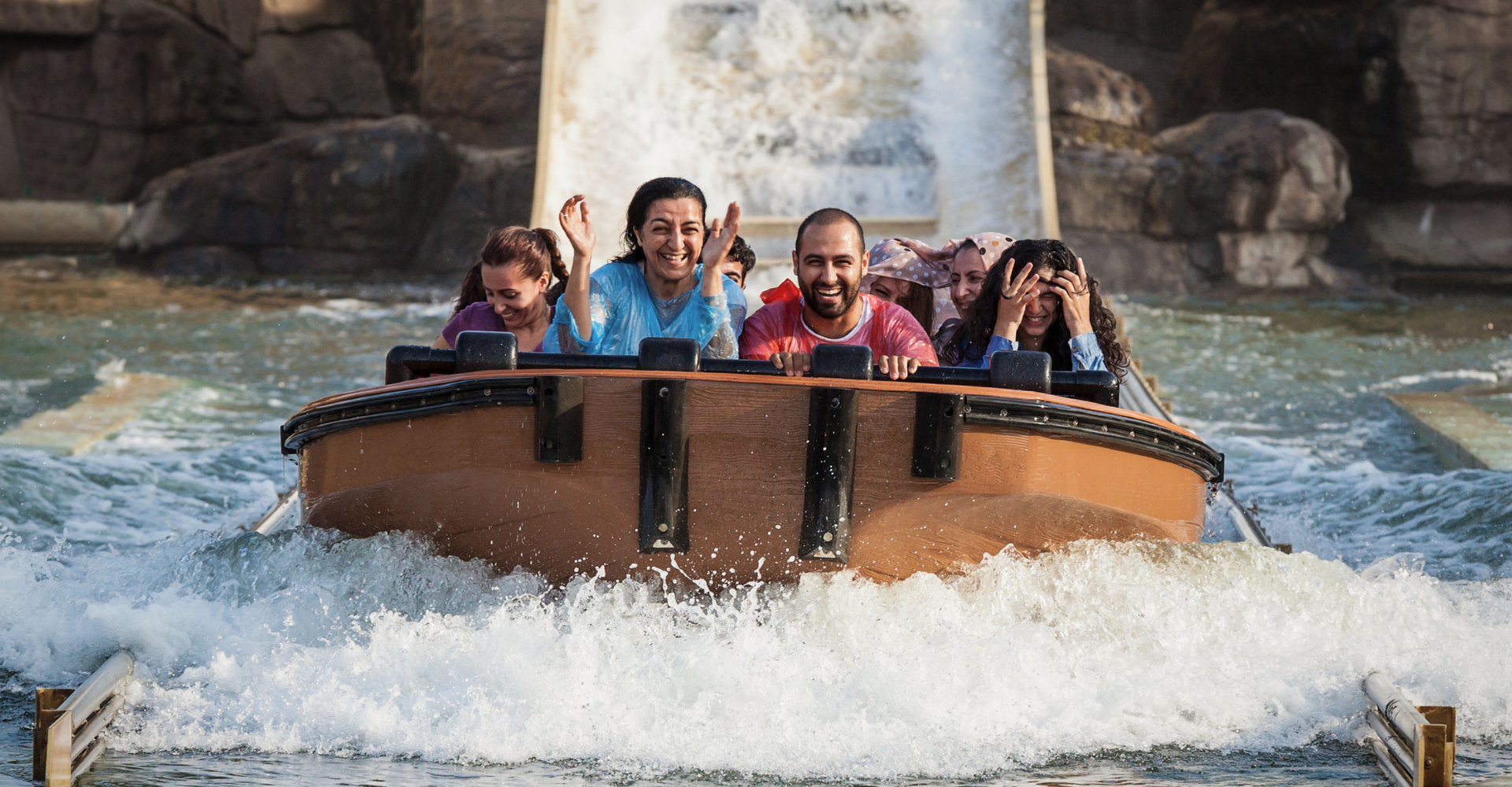 Family laughing on a log flume ride at a theme park
