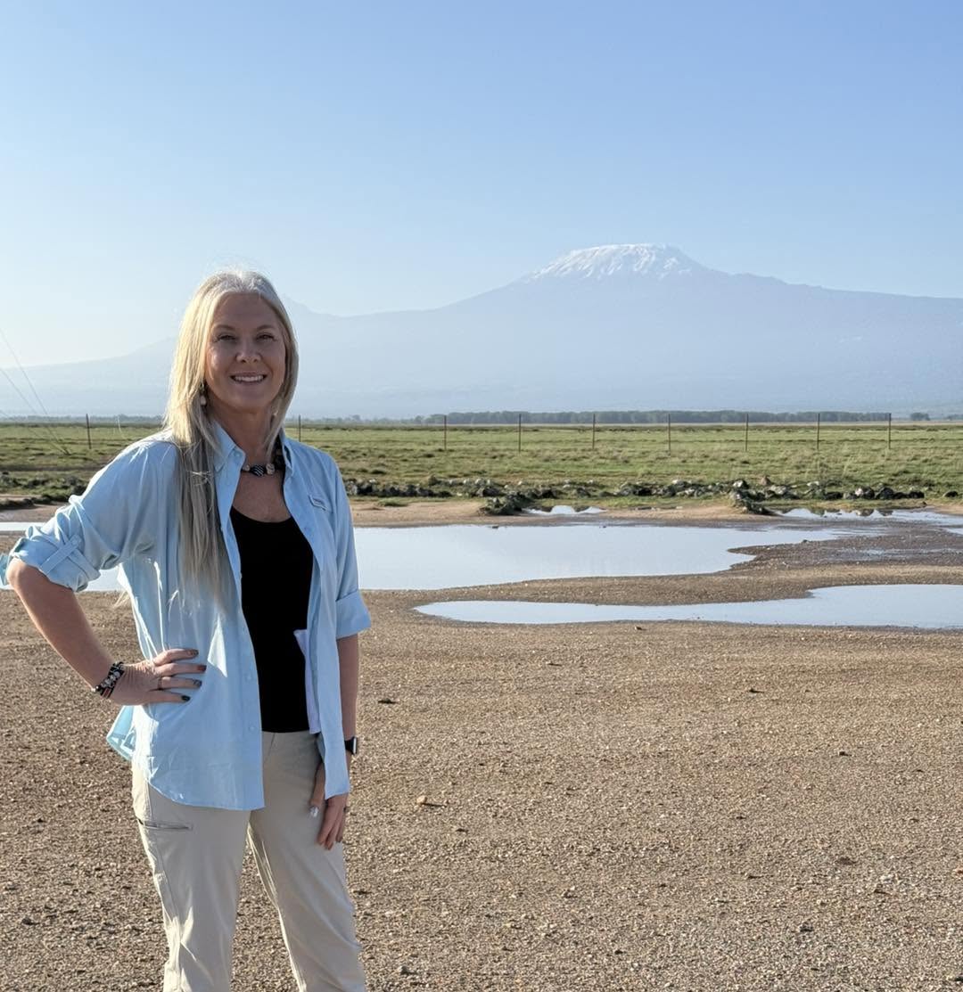 Jenipher Smith of Fulfilling Dreams Travel on safari with Mount Kilimanjaro behind her