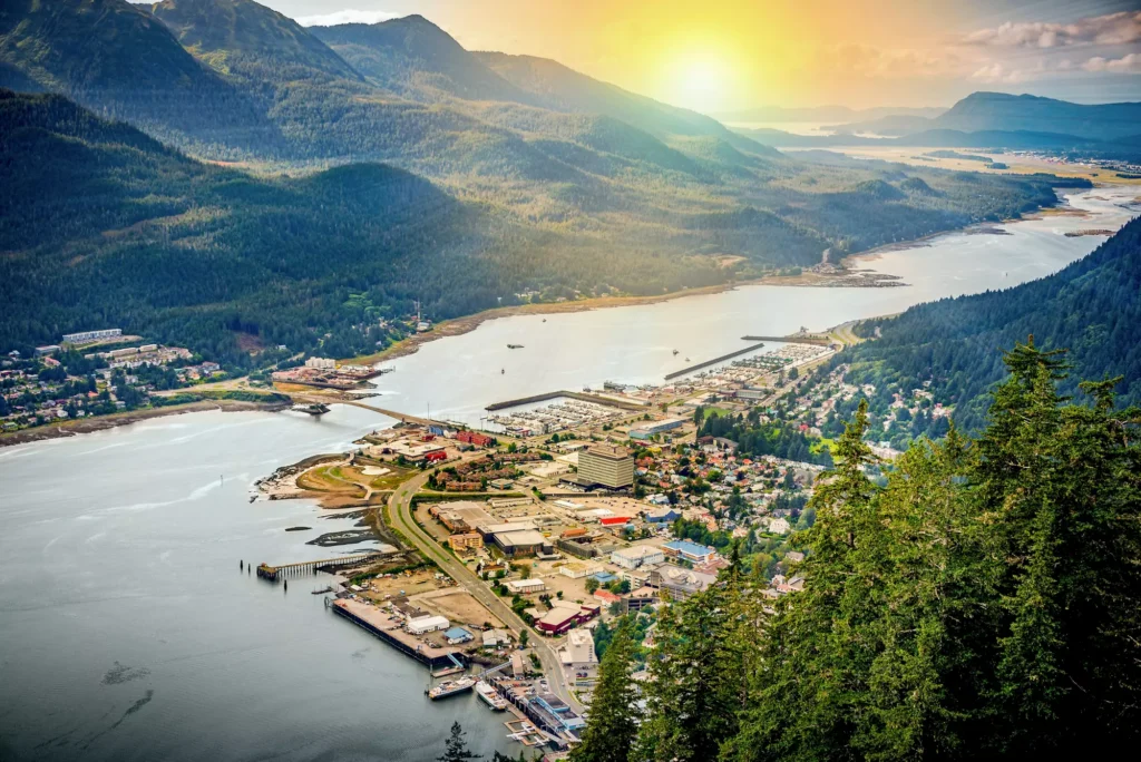 A breathtaking aerial view of Juneau, Alaska, showcasing mountains and a serene sea at sunrise