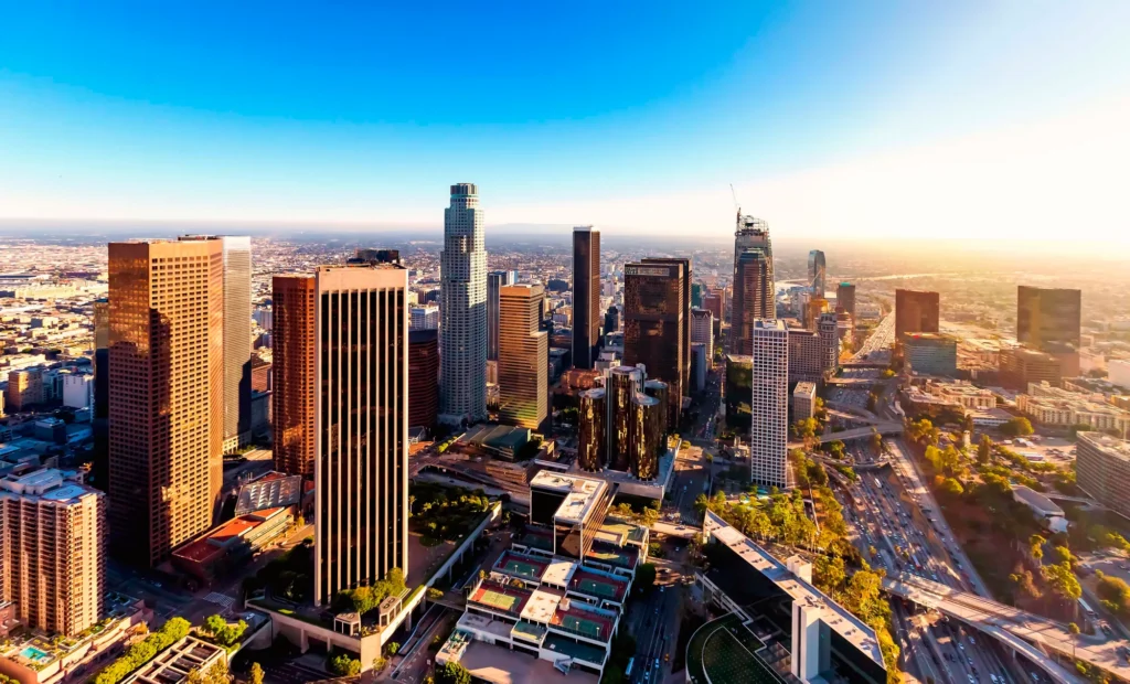 A breathtaking view of the Los Angeles skyline illuminated by the sunset, showcasing the city's beauty