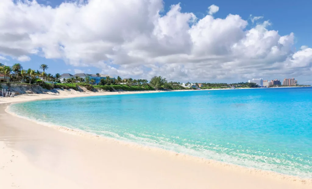 A serene beach with soft sands and clear blue waters under a bright sky in Nassau, Bahamas
