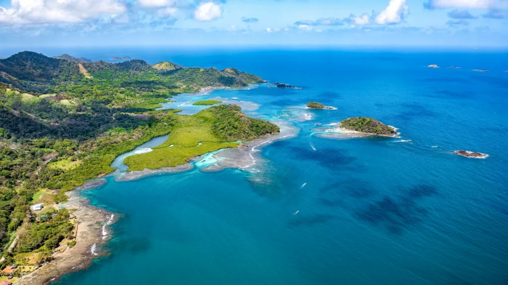 Aerial view of a lush coastline in the Republic of Panama, featuring vibrant greens and deep blue waters