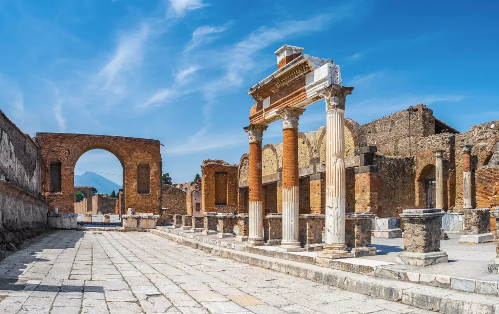 Ancient ruins of Pompeii with columns under a bright blue sky