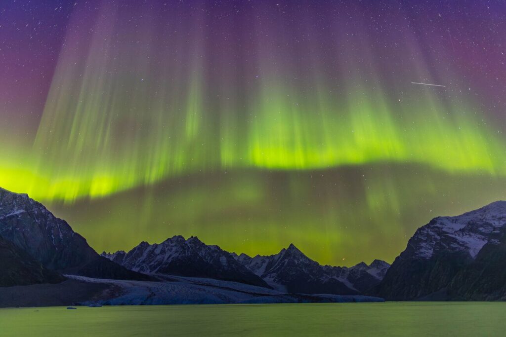 Aurora borealis over snowy Arctic mountains
