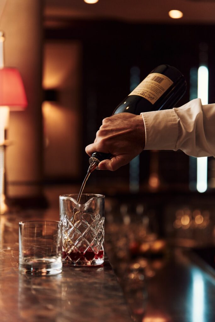 Bartender pouring a craft cocktail aboard Crystal