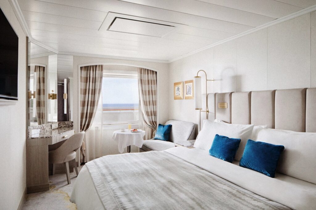 Bright Crystal Serenity suite with sitting area and ocean-view windows