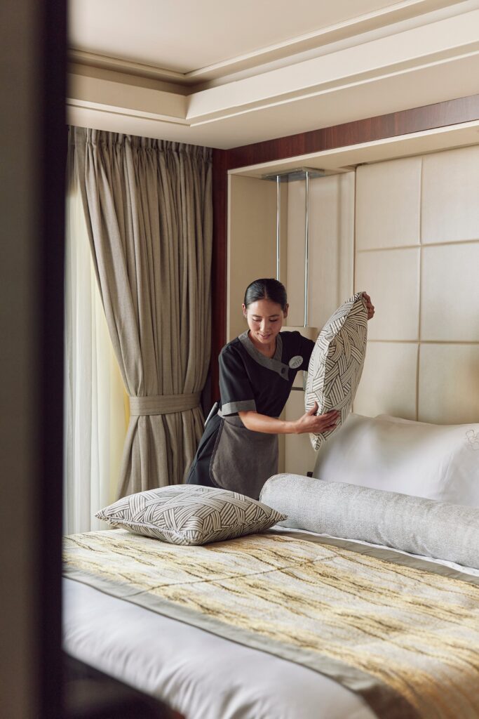 Crew member preparing a suite turndown aboard Crystal
