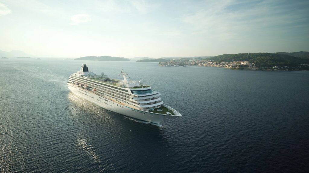 Crystal cruise ship sailing calm coastal waters at golden hour