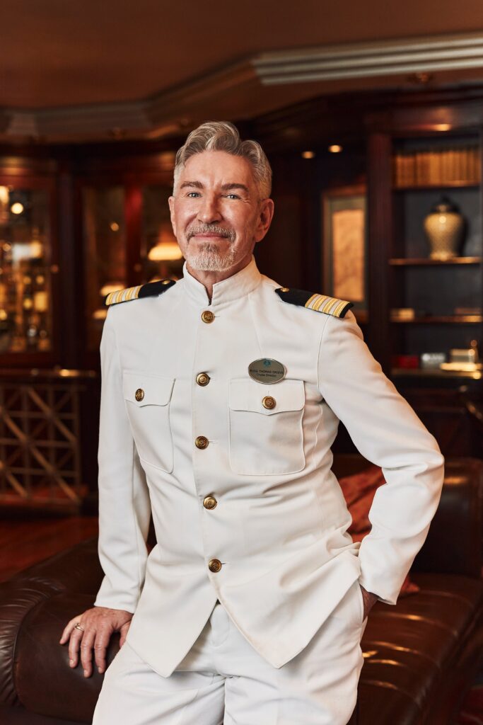 Crystal ship officer in dress whites in an onboard lounge