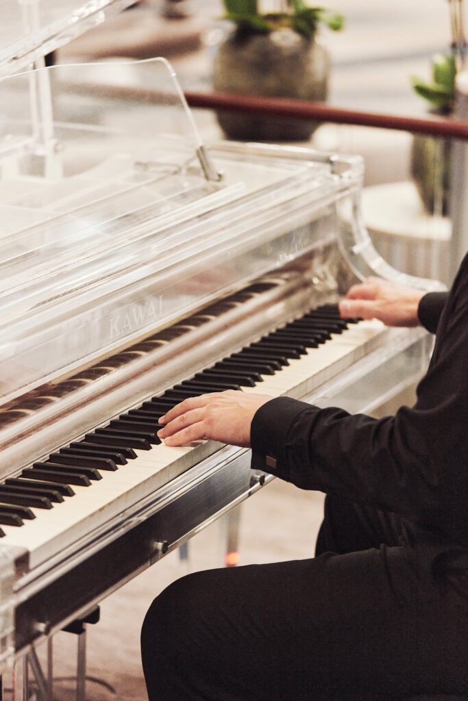 Pianist playing a glass grand piano aboard Crystal