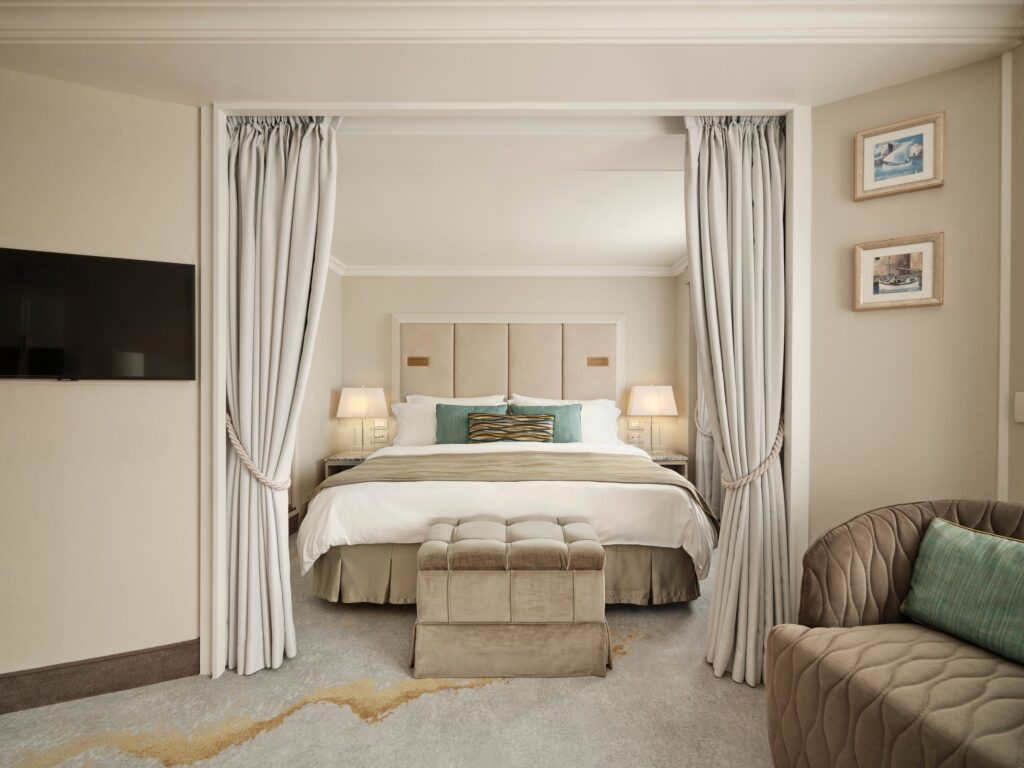 Refurbished Crystal Symphony suite with king bed and soft neutral tones