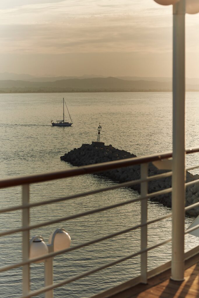 Ship railing view of a calm harbor and anchored boats from a Crystal deck