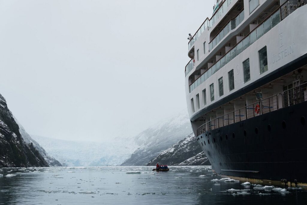 Expedition ship and Zodiac in a misty Patagonian fjord