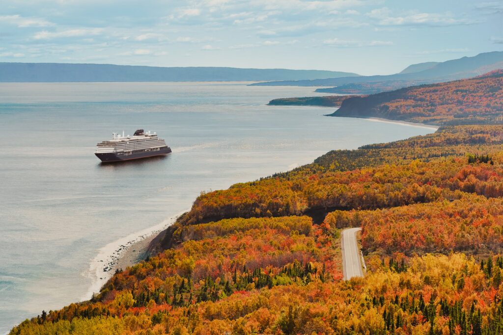 Explora IV sailing past fall foliage in Canada