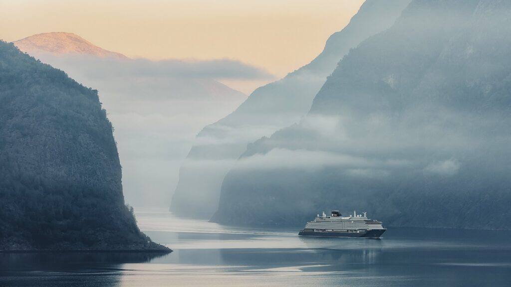 Explora Journeys ship cruising a Norwegian fjord