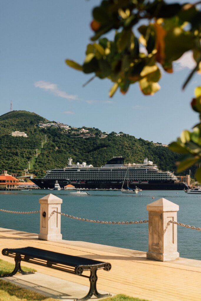 Explora Journeys ship docked at a green Caribbean island