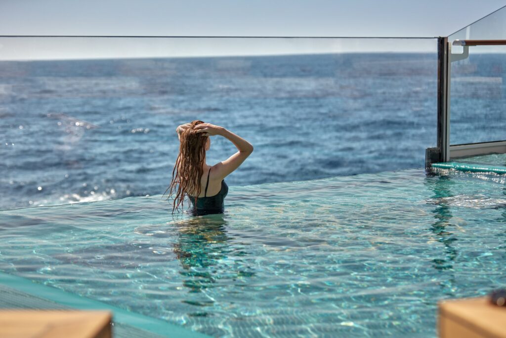 Guest in the infinity-edge Astern Pool aboard Explora Journeys