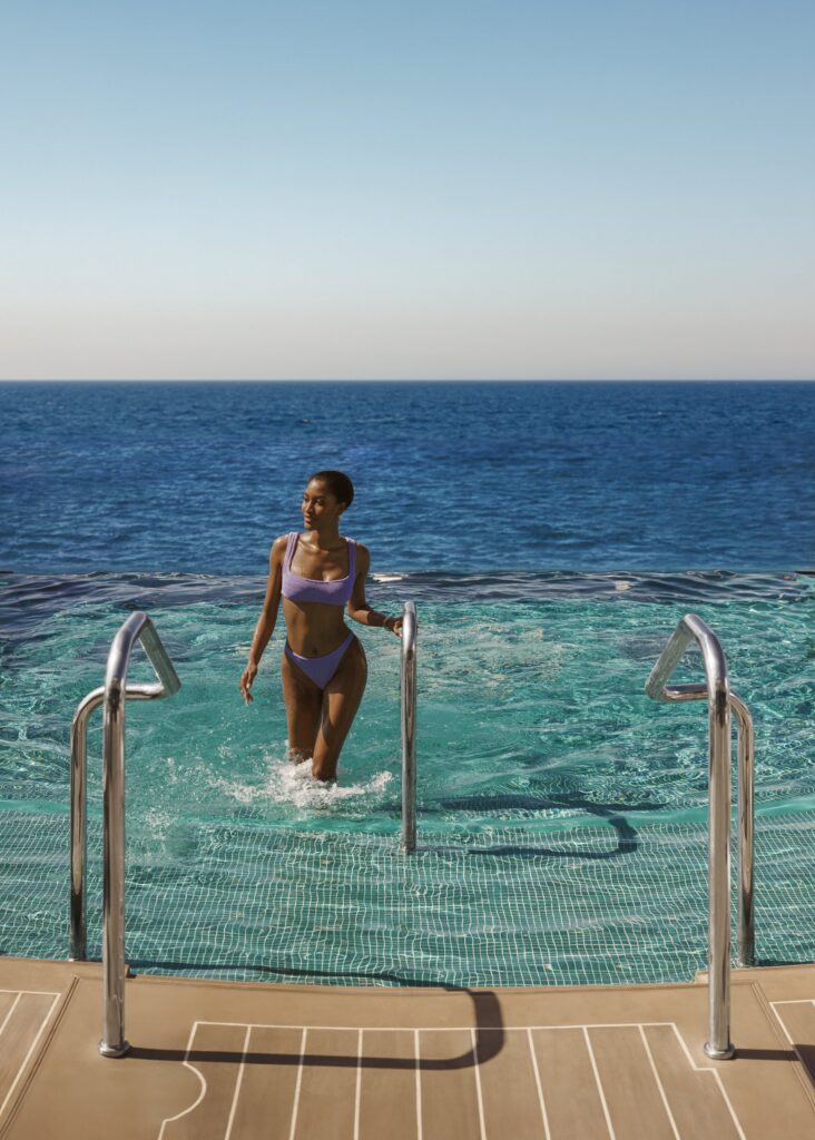 Guest stepping into the pool aboard Explora Journeys