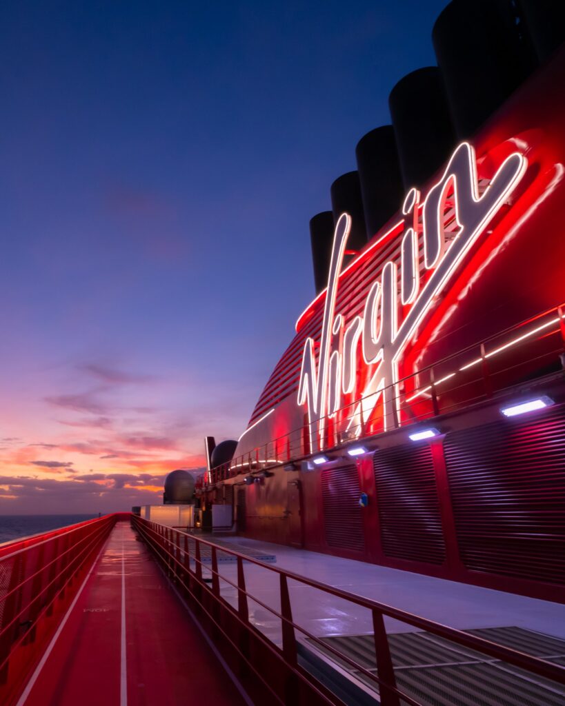 Illuminated Virgin sign on deck at sunset