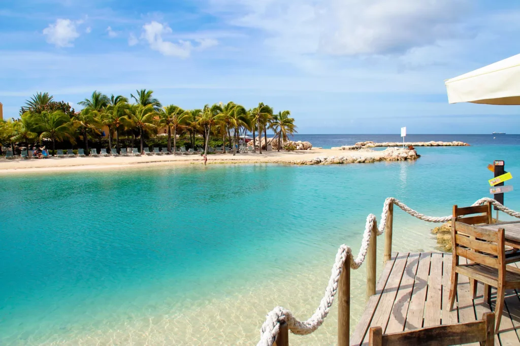 Mambo Beach in Curacao with calm blue water and palm trees