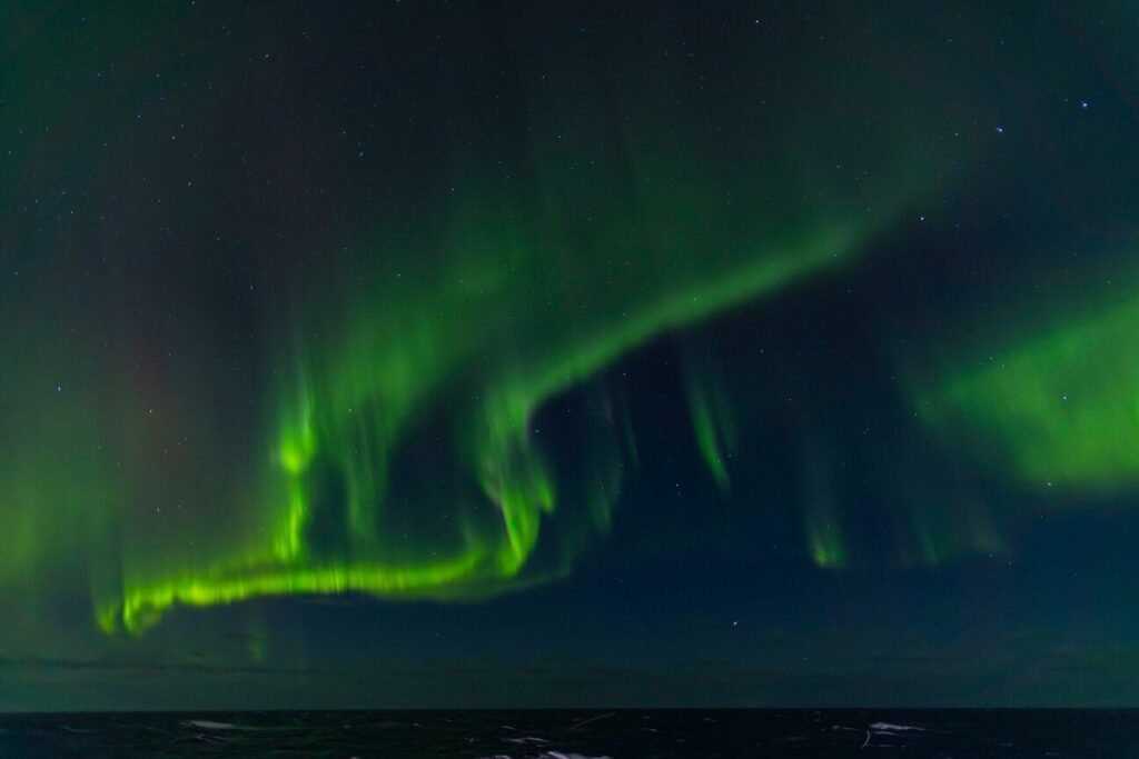 Northern lights glowing green over the night sky