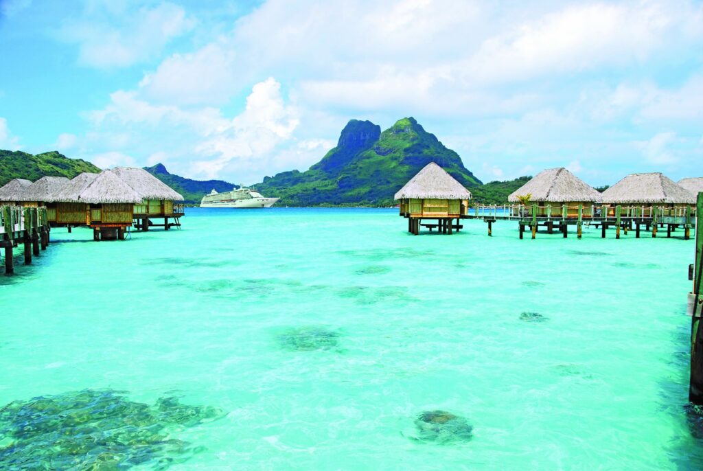 Overwater bungalows in a turquoise South Pacific lagoon
