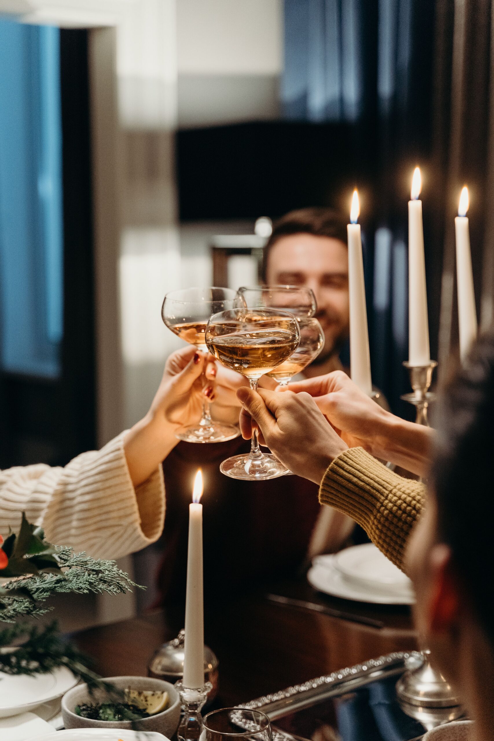 Friends raising a toast at a candlelit dinner celebration