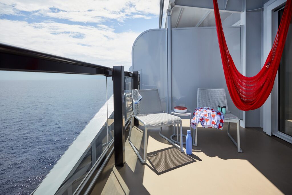Sea Terrace cabin balcony with red hammock aboard Virgin Voyages